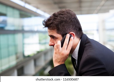 Close-up Of A Successful Young Business Man Talking On Cell Phone At Modern Office