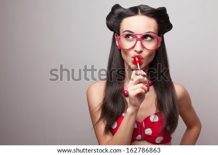 Closeup of sucking a lollipop model in red and white dotted costume