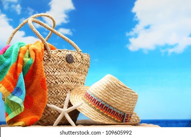 Closeup of summer beach bag and straw hat on sandy beach. - Shutterstock ID 109605992