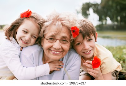 Closeup summer portrait of happy grandmother with grandchildren outdoors - Powered by Shutterstock