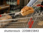 Close-up of a supermarket shopping trolley and a woman