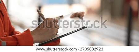 Close-up at supervisor hand is using pen to checking on project risk assessment form to evaluate serverity level. Industrial or business working scene. 