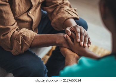 Closeup of a support hands. Closeup shot of a young woman holding a senior man's hands in comfort. Female carer holding hands of senior man  - Shutterstock ID 2127650324