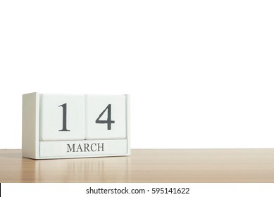 Closeup surface white wooden calendar with black 14 march word on blurred brown wood desk isolated on white background with copy space , selective focus at the calendar