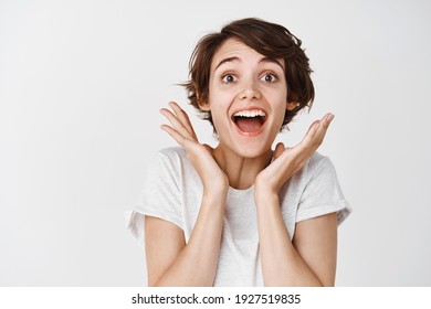 Close-up Of Surprised And Happy Woman Gasping Amazed, Saying Wow Astounded, Look Fascinated At Camera, White Background.