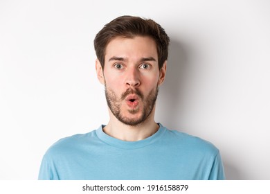 Close-up Of Surprised Man Face, Saying Wow And Staring At Camera Amazed, Standing On White Background