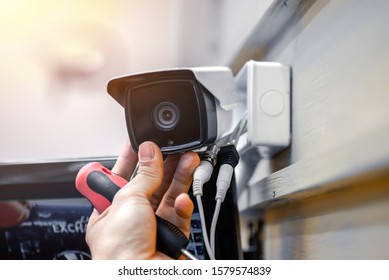 Close-up Of Surveillance Camera Installation, Male Hand Holds Cctv Camera