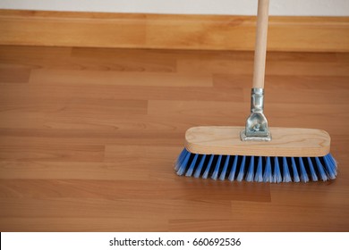 Close-up Of Sweeping Broom With Wooden Handle On Floor