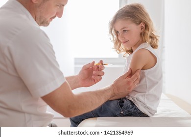 Close-up Of A Sweet Blond Boy And A Doctor With A Syringe