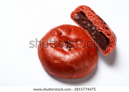 A close-up of a sweet red bean paste bread, showing its soft interior and nutty filling.