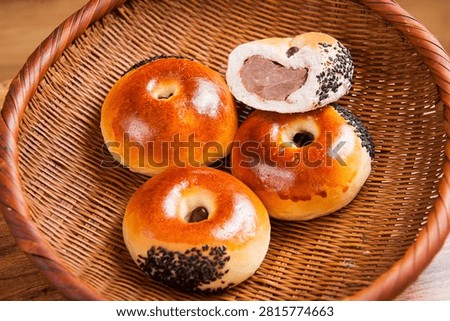 A close-up of a sweet red bean paste bread with a nutty filling, showing its soft interior.
