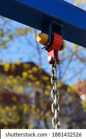 A Closeup Of A Swing Chain Hanging From A Blue Metal Bar