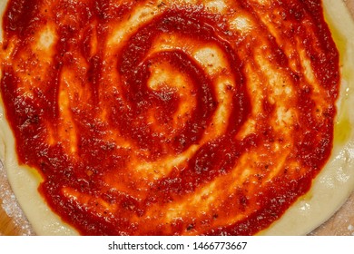 Closeup Of A Swirl Of Pizza Sauce On A Pizza Dough