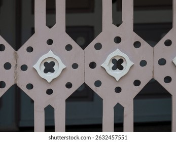 Close-up of a symmetrical wooden panel with carved geometric and floral shapes, painted in muted pastel tones. - Powered by Shutterstock - Get 15% off with code: PIKWIZARD15