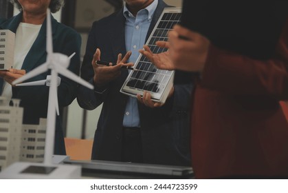 Close-up at tablet, Engineers pointing at tablet with their hands. To jointly design the use of renewable energy with wind and solar energy. Concept of using renewable energy.
