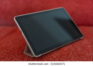 close-up tablet on an old couch.