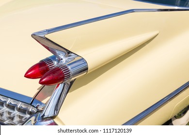 Close-up of tail light and rear part of retro car. Detail of vintage classic vehicle. Wing fender with chrome bumper and red brakelights.