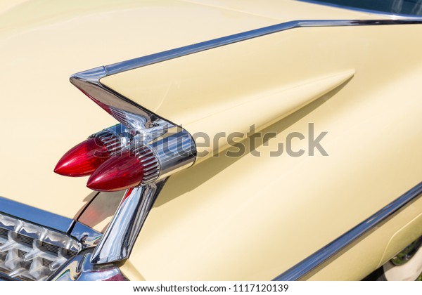 Close-up of tail light and rear part of\
retro car. Detail of vintage classic vehicle. Wing fender with\
chrome bumper and red\
brakelights.