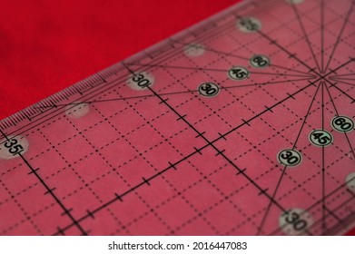 Closeup of tailor's patter on a red fabrics. Hobby and sewing concept. Handmade clothes concept. Tools for tailoring - Powered by Shutterstock