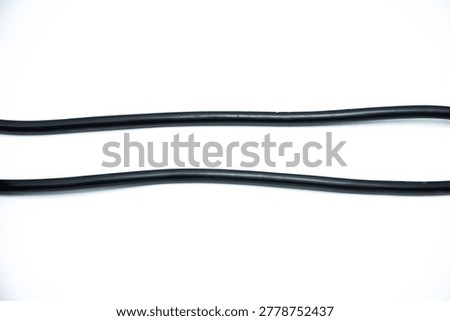 Close-up of tangled  black Electrical Cables with Exposed Copper Wires on White Background. Electric cables plug used to instalation in commercial and industrial Electrical Systems. Macro detail of stripped and rolled.  
