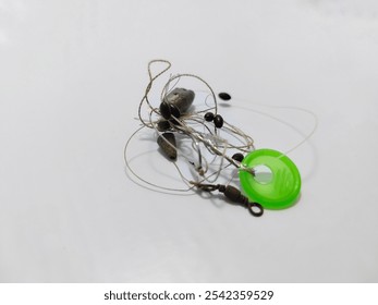 A closeup of a tangled fishing line with attached weights and swivel, set on a plain white background. Perfect for concepts of fishing gear, disorganization, and hobby preparation. - Powered by Shutterstock