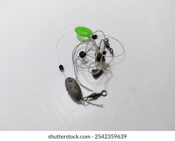 A closeup of a tangled fishing line with attached weights and swivel, set on a plain white background. Perfect for concepts of fishing gear, disorganization, and hobby preparation. - Powered by Shutterstock