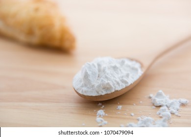  Close-up of tapioca starch or flour powder in wooden spoon with wooden background