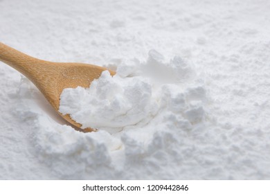 Close-up of tapioca starch or flour powder in wooden spoon with starch background