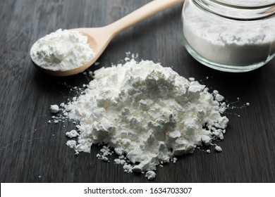 Close-up of tapioca starch or flour powder in wooden spoon with wooden background