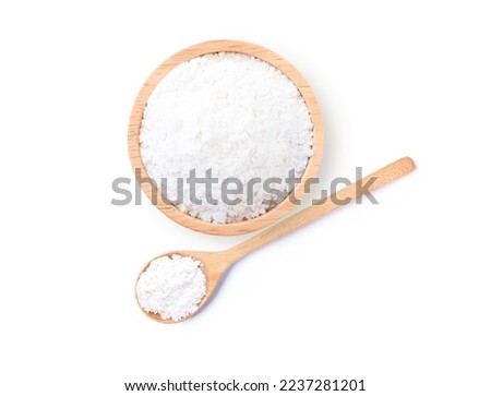Closeup tapioca starch (potato flour or powder) in wooden bowl and spoon isolated on white background. Top view. Flat lay.
