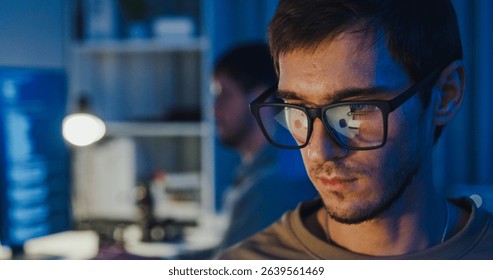 Closeup team adult male freelance work late typing write prompt AI bot app program nomad terminal code at office night. Artificial intelligence dashboard, robotics, user interface, machine learning.
