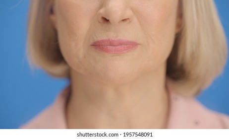 Close-up Tearful Lips Of The Old Woman In Front Of A Blue Background. Close Up, Crying Lips Concept.