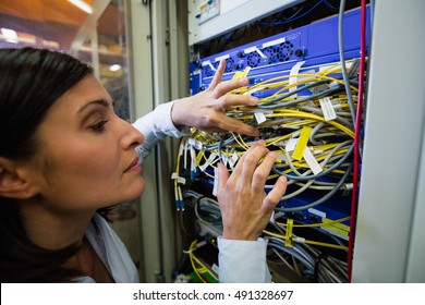 Close-Up of technician checking cables in a rack mounted server - Powered by Shutterstock