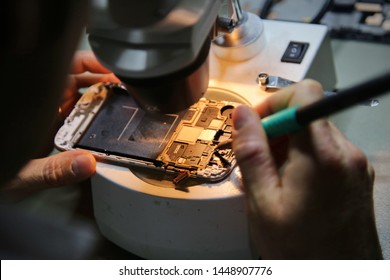 Close-up Of A Technician Hand Repairing Mobile Phone