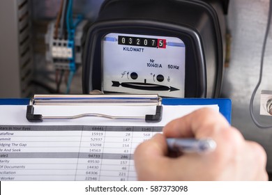 Close-up Of A Technician Hand Writing Reading Of Meter On Clipboard - Shutterstock ID 587373098