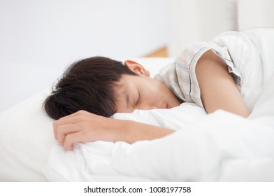 Closeup Of A Teen Boy Sleeping On A Bed.
