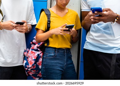 Close-up Of Teen High School Students Using Mobile Phone In School Corridor. Social Media Concept. Cellphone Addiction Concept.