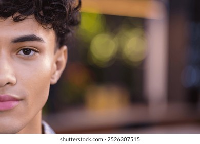 Close-up of teenage boy with curly hair, half face visible, looking confident, copy space. Confidence, portrait, determination, expressive, motivation, self-assured - Powered by Shutterstock