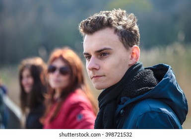 Closeup Of A Teenage Boy With His Family In The Background