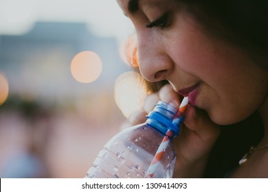 Close-up of teenage girl drinking cold drink with paper straw - Powered by Shutterstock