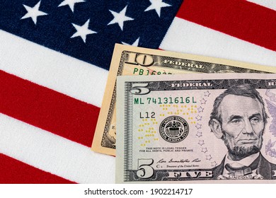 Closeup of ten and five dollar bills with American flag.  Concept of 15 dollar federal minimum wage increase