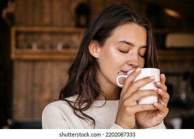 Close-up tender young caucasian lady closing her eyes spends lazy day enjoying chamomile tea. Brunette girl wears casual clothes in camping spring. Lifestyle concept - Powered by Shutterstock