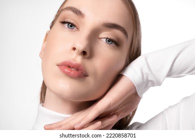 Close-up of a tender young woman with perfect soft skin with natural makeup on a white background.
