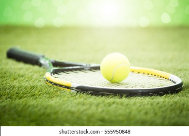 Close-up Of Tennis Racket With Green Ball On Grass