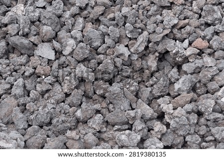 close-up texture background of dark volcanic lava rock and porous basalt stones