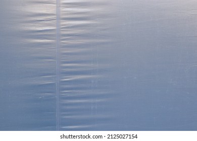 close-up texture of blue, gray plastic canvas textile with stitched or seam.
