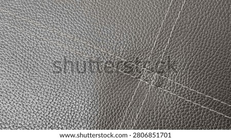 Close-up Texture of Dark Grey Leather with Crisscross Decorative Stitching
