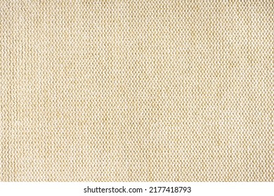 Close-up texture of natural beige coarse weave fabric or cloth. Fabric texture of natural cotton or linen textile material. Blue canvas background. Decorative fabric for upholstery, furniture, walls