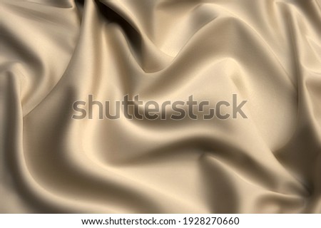 Close-up texture of natural beige fabric or cloth in brown color. Fabric texture of natural cotton or linen textile material. Beige canvas background.