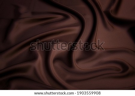 Close-up texture of natural cocoa fabric or cloth in same color. Fabric texture of natural cotton, silk or wool, or linen textile material. Red canvas background.